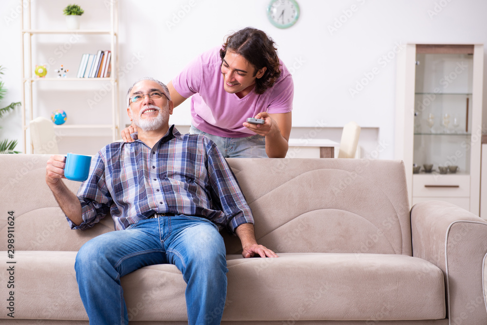 Young student and his old grandpa at home Young student and his old grandpa at home