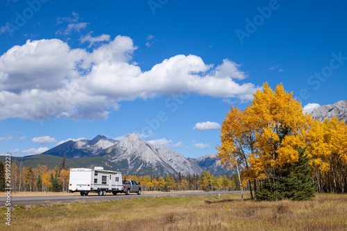 An RV aon the highway through the Canadian Rocky Mountains in Kananaskis, Alberta, Canada during the peak of autumn colors