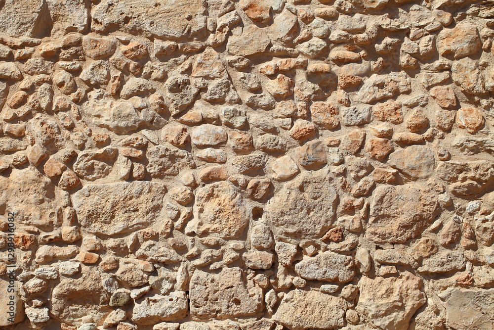 The wall of old stone masonry beige. The wall of old stone masonry beige.