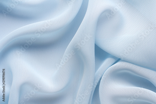 delicate blue fabric with large folds, textile background photo