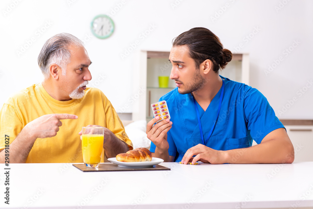 Young male doctor visiting old patient at home Young male doctor visiting old patient at home
