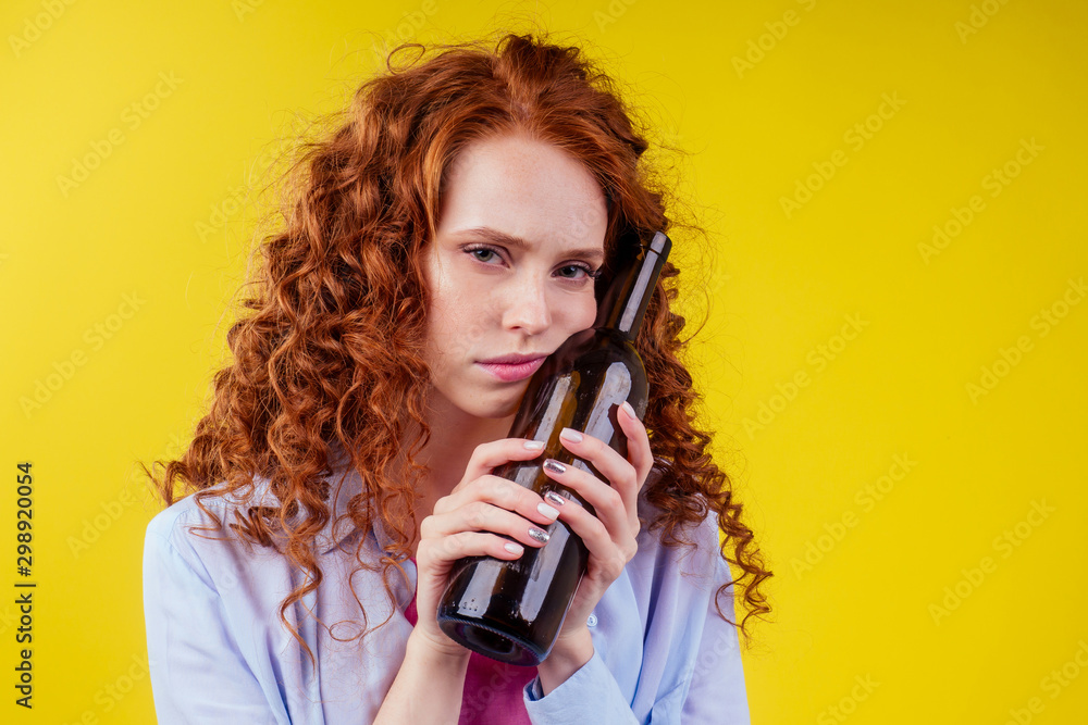 curly redhead ginger woman drinking beer and feeling bad mood in csudio yellow background curly redhead ginger woman drinking beer and feeling bad mood in csudio yellow background