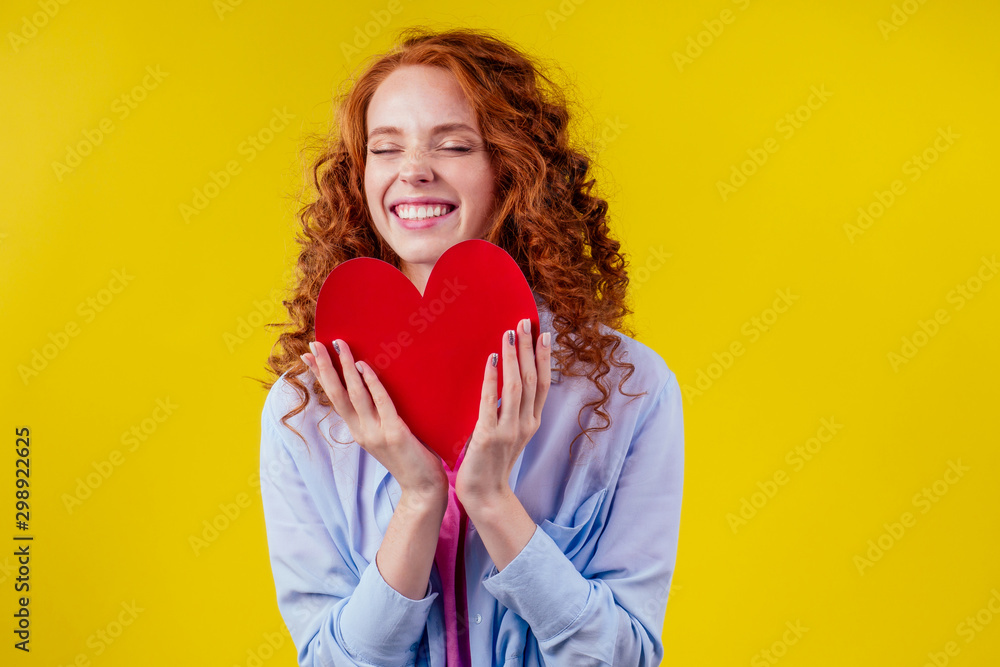 cardiologist redhaired ginger curls happy woman holding paper heard in studio yellow background cardiologist redhaired ginger curls happy woman holding paper heard in studio yellow background