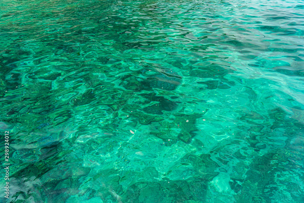 Stone in the emerald blue water in the sea.