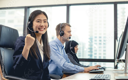 Successful of beautiful Asian woman and group of diverse telemarketing customer service staff team in call center.
