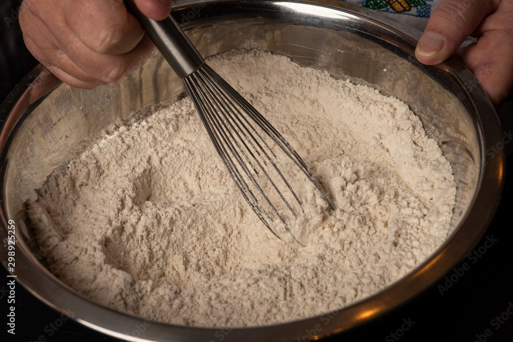 Fototapeta premium Cookie mix is stirred with a whisk in a bowl