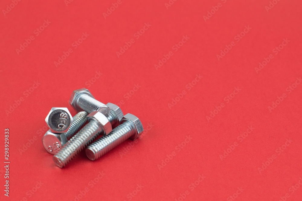 Stainless steel screws on red background Stainless steel screws on red background