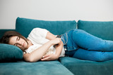 young woman fall asleep on the sofa while watching TV in the living room