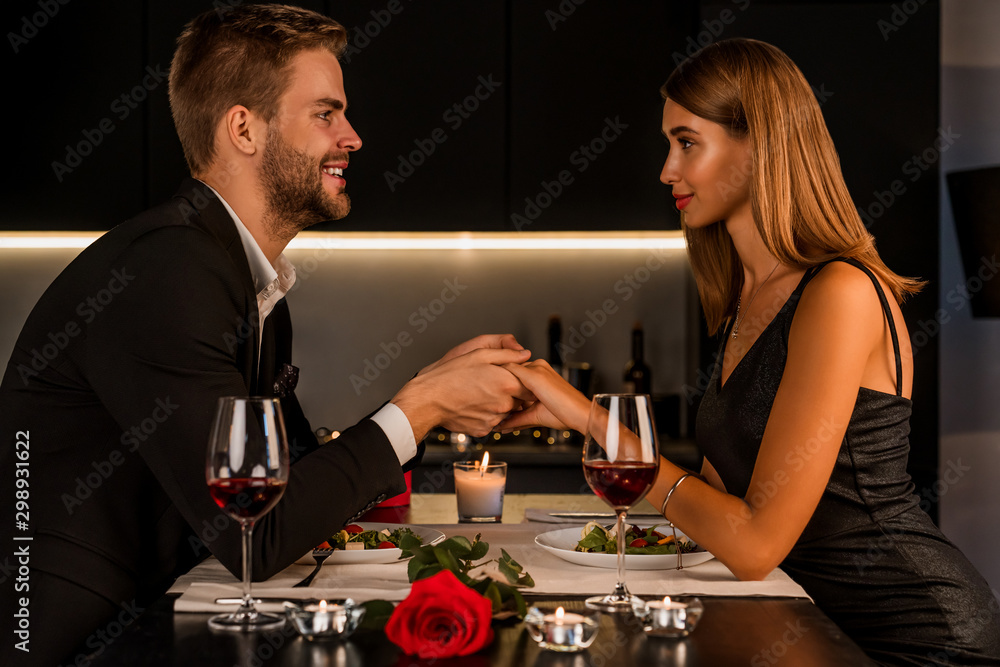 Pleased happy married couple having romantic dinner in candlelight