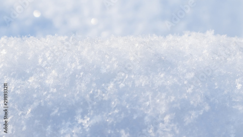 Background of fresh snow. Natural winter background. Snow texture in blue tone