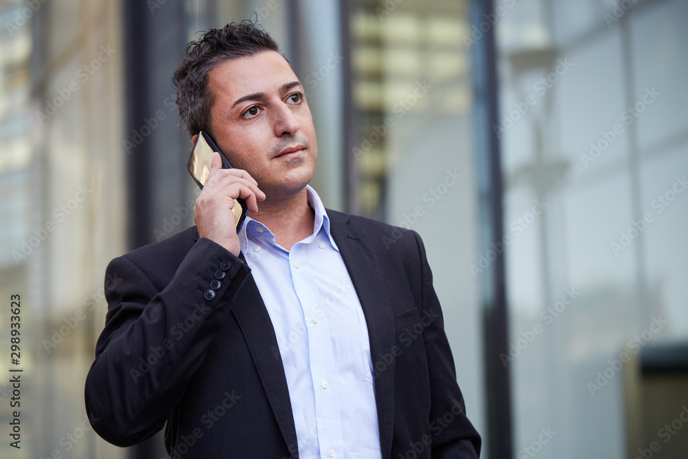 businessman talking to mobile in urban environment businessman talking to mobile in urban environment