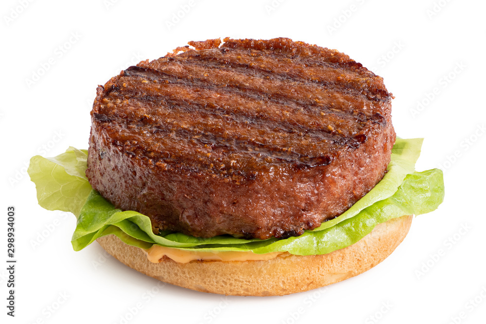 Freshly grilled plant based burger patty on bun with lettuce and sauce isolated on white.