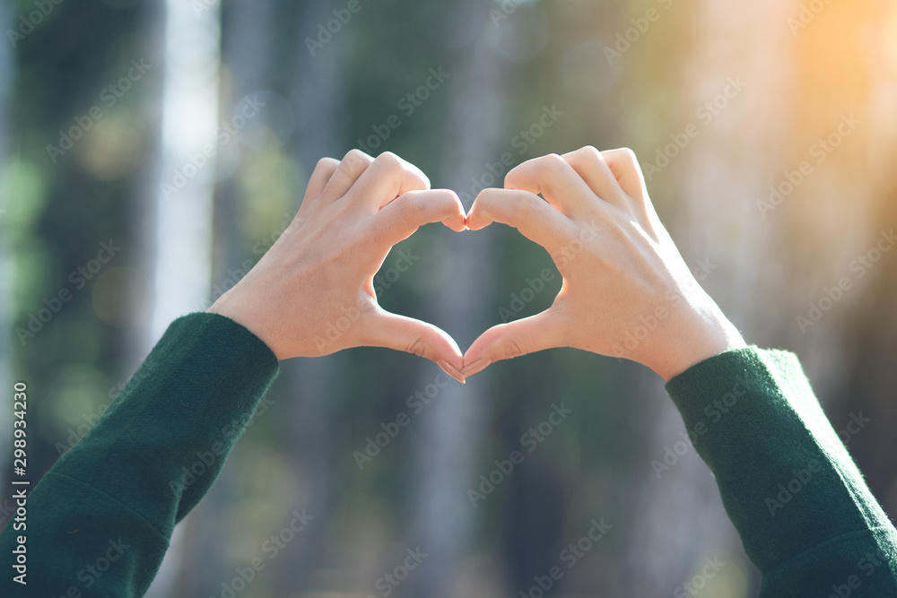 woman finger heart in the nature woman finger heart in the nature