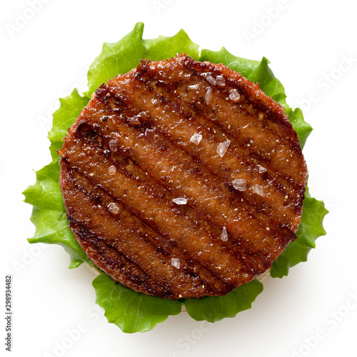 Freshly grilled plant based burger patty on bun with lettuce and rock salt isolated on white Fototapet