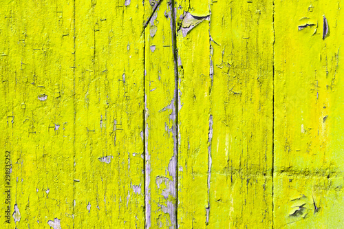 Yellow wooden surface texture with peeling paint