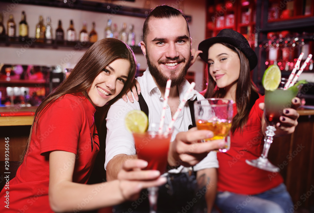 Time Selfie. A group of friends at a party in a nightclub clink glasses with alcoholic beverages. Happy young people with cocktails in the pub. Time Selfie. A group of friends at a party in a nightclub clink glasses with alcoholic beverages. Happy young people with cocktails in the pub.