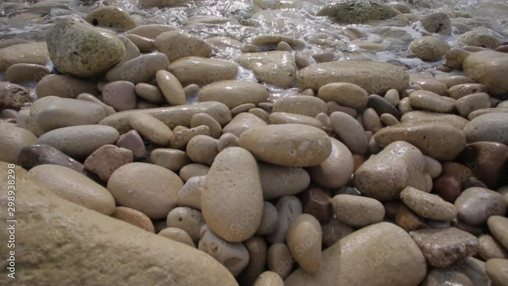 On a rocky shore of the sea. Waves roll with noise onto a rocky shore. Sunset by the Mediterranean sea On a rocky shore of the sea. Waves roll with noise onto a rocky shore. Sunset by the Mediterranean sea
