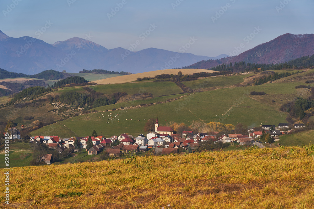 Landscape Picture of mountain countryside in Slovakia, europe in sunny autumn evening. Small village between fields and meadows of Mala and Velka Fatra mountain range in north west of Slovak Republic.