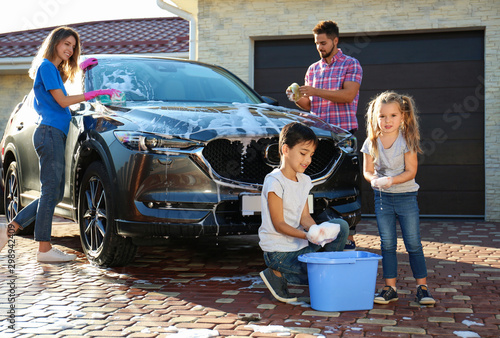 Fotografía Happy family washing car at backyard on sunny day
