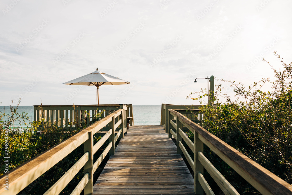 Beach boardwalk with wooden pathway and umbrella 