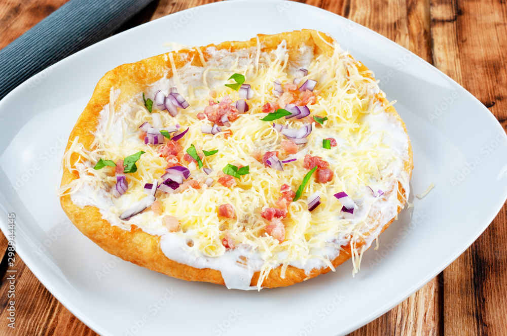 Langos with bacon and cheese - Hungarian fried dough food.