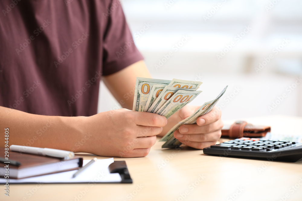 Man counting American money at table, closeup Man counting American money at table, closeup