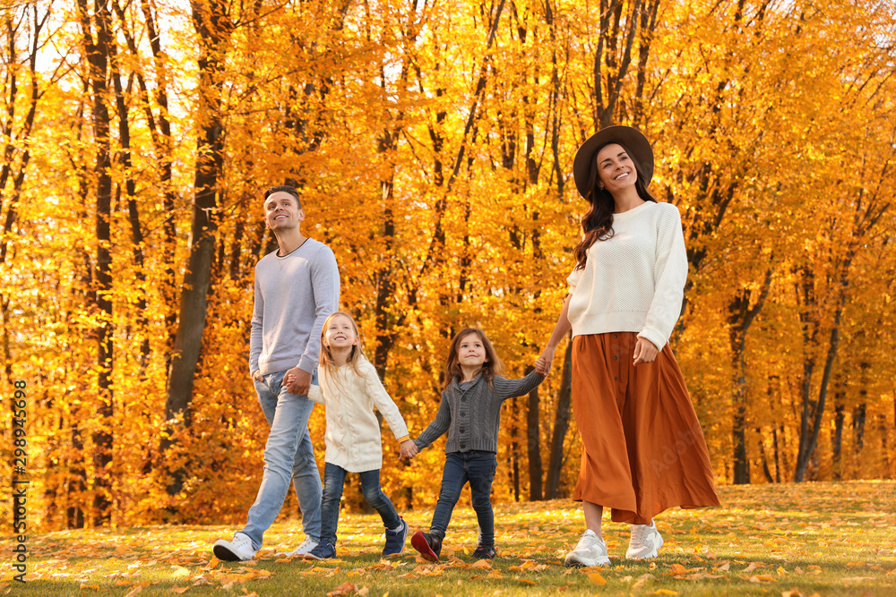 Fototapeta premium Happy family with little daughters walking in autumn park