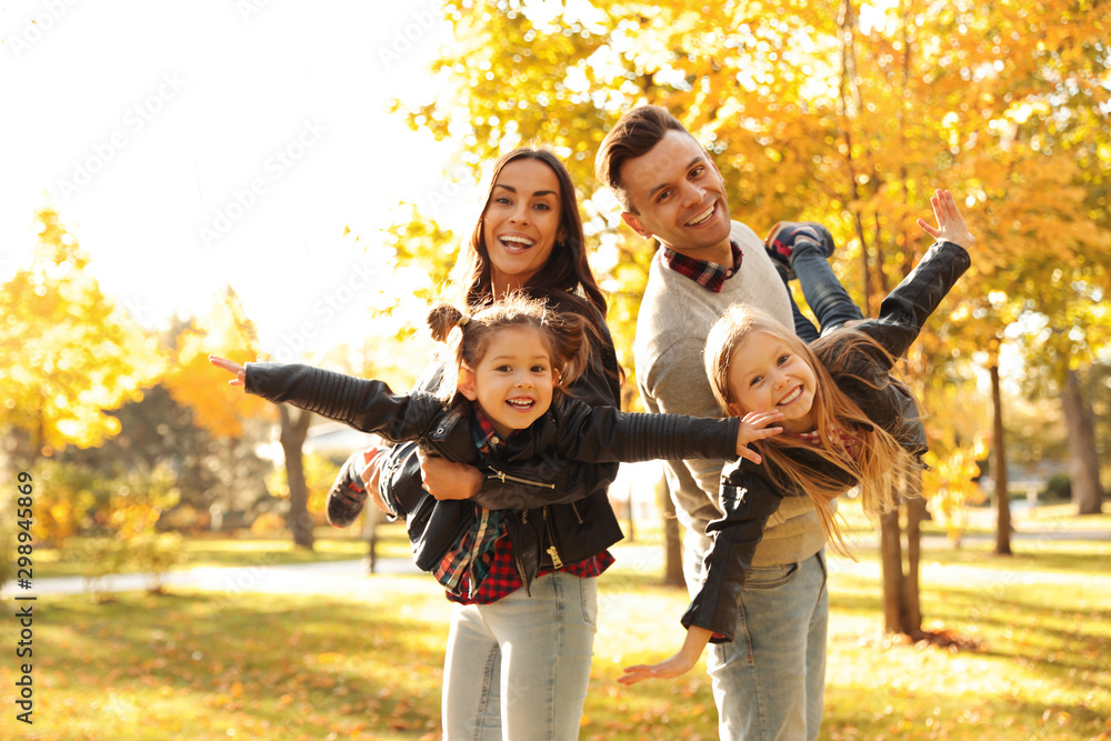 Happy family with little children in sunny park. Autumn walk - obrazy, fototapety, plakaty 