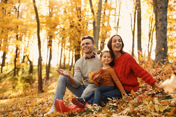Happy family with little daughter in park. Autumn walk