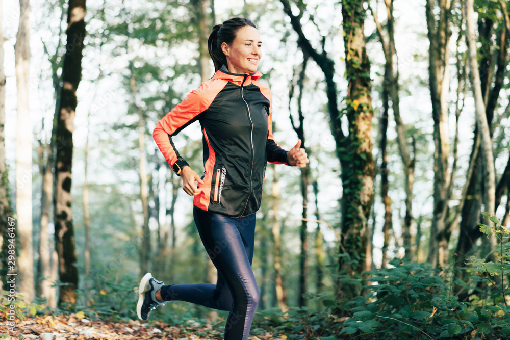 Portrait of a runner woman in a forest. Healthy lifestyle concept.