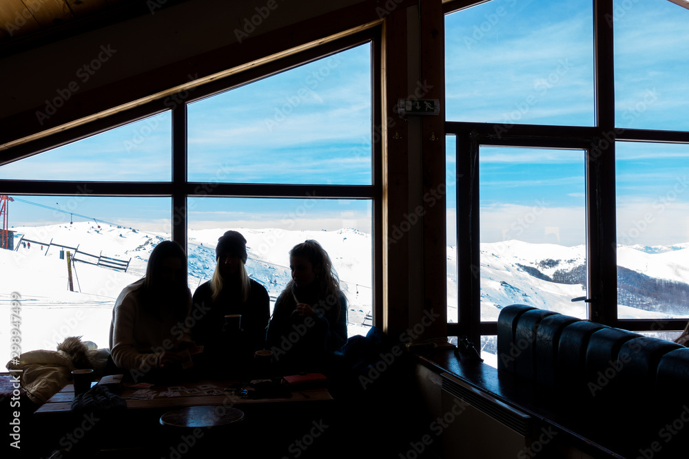 The silhouettes of three young ladies in the cosy atmosphere in the chalet of 3-5 Pigadia ski center The silhouettes of three young ladies in the cosy atmosphere in the chalet of 3-5 Pigadia ski center