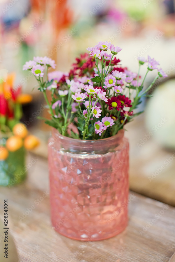 Beautiful autumn seasonal flowers in pink glass vase