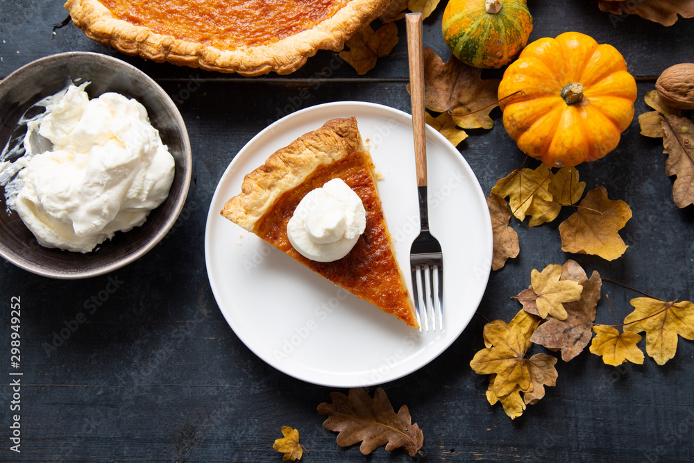 Fototapeta premium Portion of homemade thanksgiving pie with whipped cream