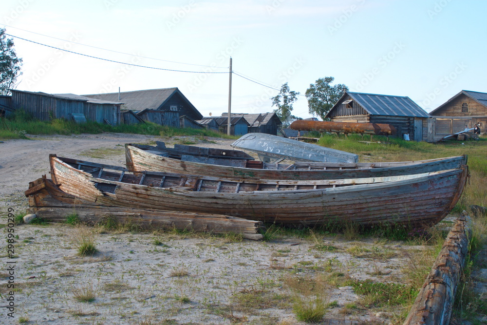 Broken wooden boat on the shore of the White sea. Solovetsky Islands, Russia Broken wooden boat on the shore of the White sea. Solovetsky Islands, Russia