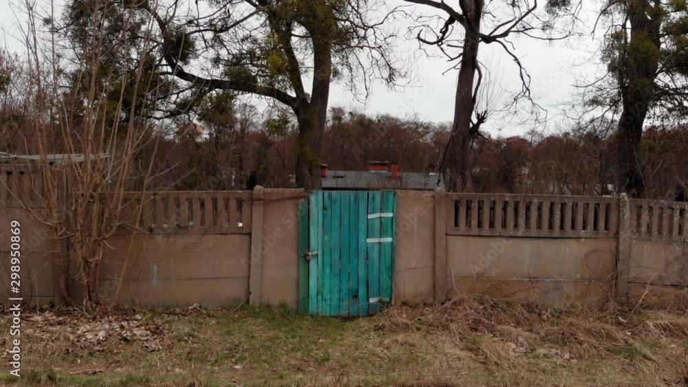 A dolly shot of a blue door in the centre on a concrete fence behind abandoned railway tracks. A dolly shot of a blue door in the centre on a concrete fence behind abandoned railway tracks.