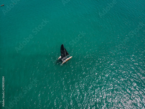 Bird eye view of the small sailing kayak; black sails in the wind. Regatta concept.
