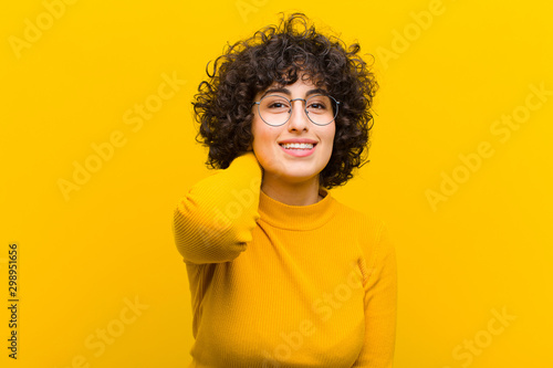 young pretty afro woman laughing cheerfully and confidently with a casual, happy, friendly smile