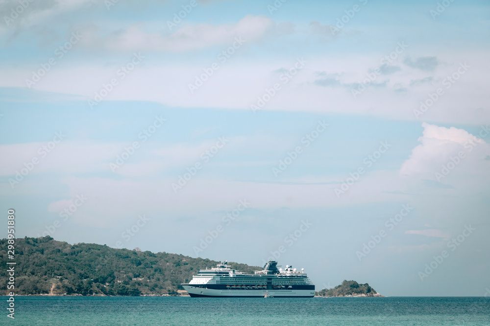 Huge white cruise ship sails the turquoise Andaman sea; low angle shot; luxury tourism concept. Huge white cruise ship sails the turquoise Andaman sea; low angle shot; luxury tourism concept.