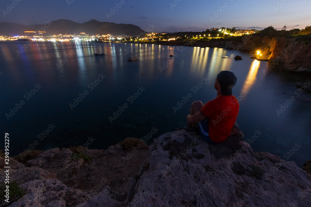 Fototapeta premium the guy on the edge of the cliff looks into the distance