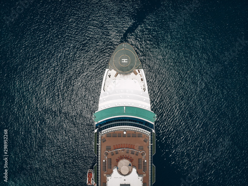 Aerial view of the deck, snout of the cruise liner with helideck and deck-chairs, blue sunny sea around. Liner equipment concept.