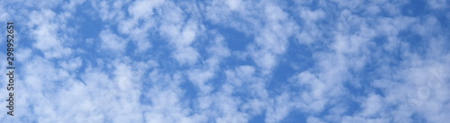 Weiße Schäfchenwolken vor blauen Himmel