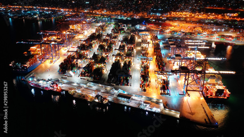 Aerial night shot of illuminated industrial cargo truck size container terminal in Perama and Drapetsona commercial port near Piraeus, Attica, Greece