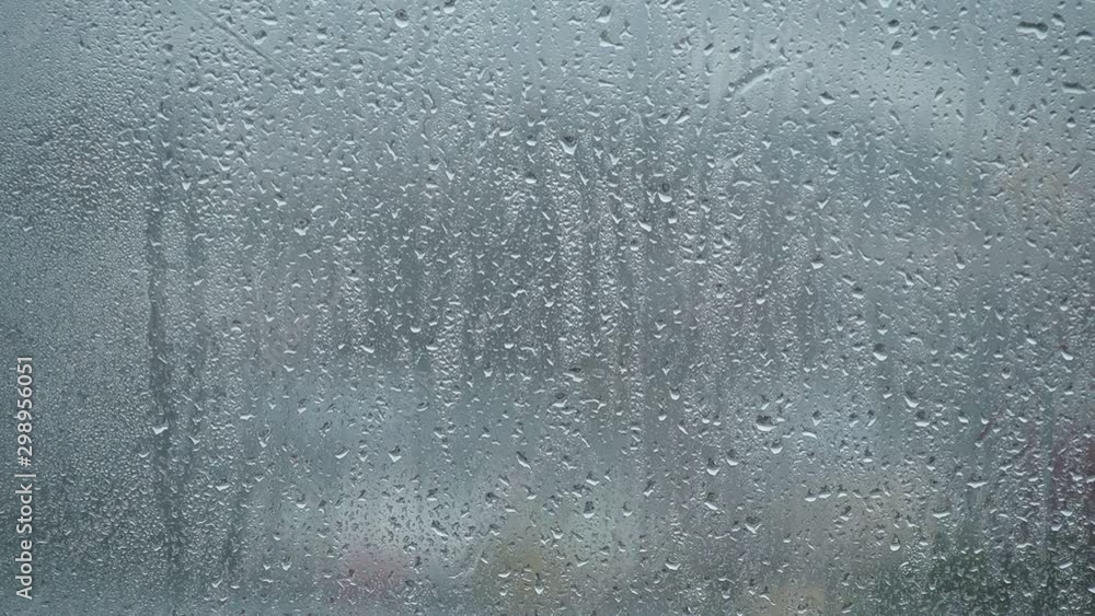 Rain drops on the glass in the spring afternoon. Close up of a window with rain drops falling down.The rain drops on household windows. Focus on rain drops. concept of sadness, frustration Rain drops on the glass in the spring afternoon. Close up of a window with rain drops falling down.The rain drops on household windows. Focus on rain drops. concept of sadness, frustration