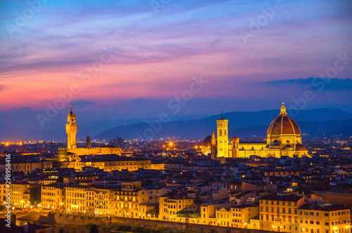 Top aerial panoramic evening view of Florence city with Duomo Cattedrale di Santa Maria del Fiore cathedral and Palazzo Vecchio palace at night dusk twilight, city lights, blue sky, Tuscany, Italy © Aliaksandr