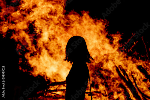 People watching fire burning at night