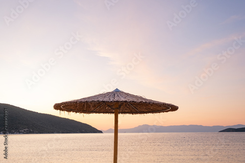 Beach umbrella in the Greece  landscape with beautiful sunrise and summer beach