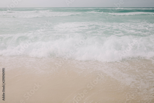 Beach with light blue water and white sand