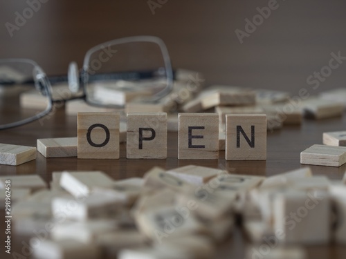 Bild auf Leinwand The concept of Open represented by wooden letter tiles