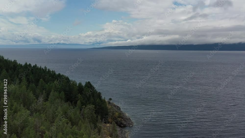 Aerial view over inlet, ocean and island with boat and mountains in beautiful British Columbia. Canada. 4K. Aerial view over inlet, ocean and island with boat and mountains in beautiful British Columbia. Canada. 4K.