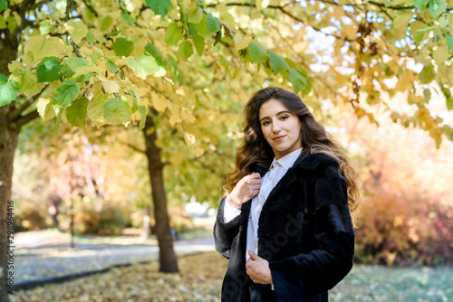 Beautiful young woman in a fur coat in the magical autumn forest.